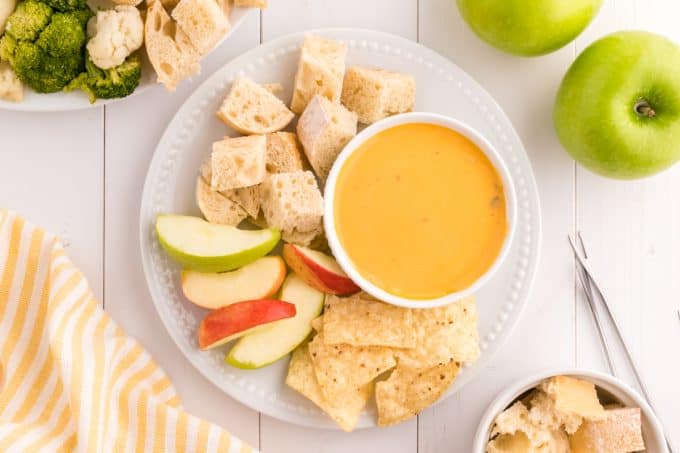 A bowl of fondue with dippers.