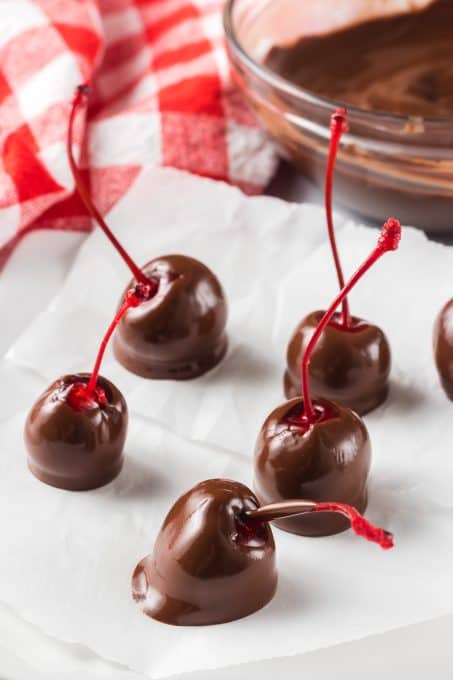 Long stem cherries that have been dipped in melted chocolate chips.