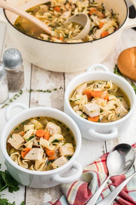 Bowls of soup made with turkey, veggies and noodles.