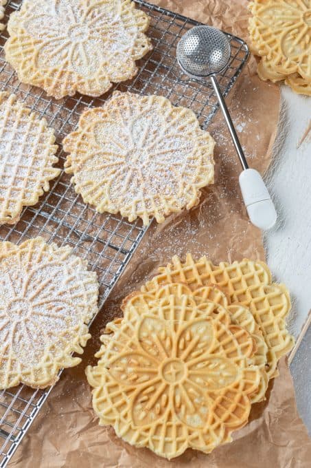 Dusting waffle cookies with powdered sugar.