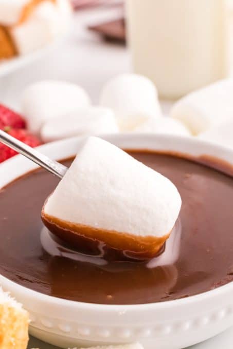 Dipping a marshmallow in fondue.