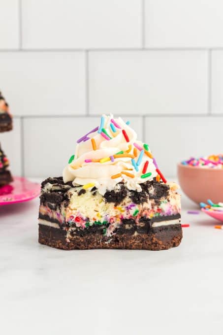 Frosting on a cheesecake bar with Oreos.