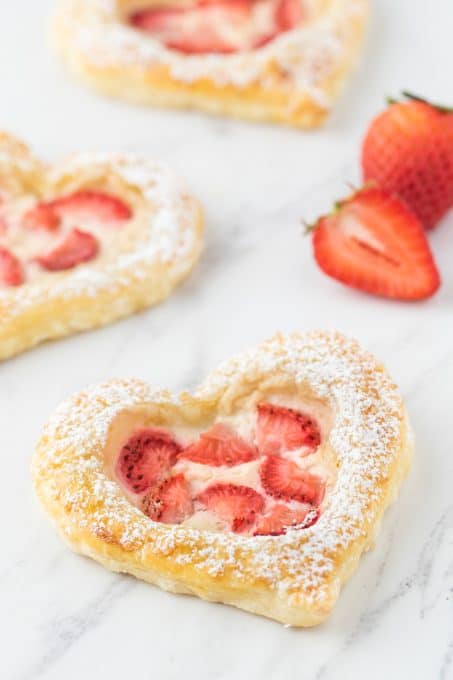 Danish shaped into hearts with sweet cream cheese and topped with fresh strawberries.