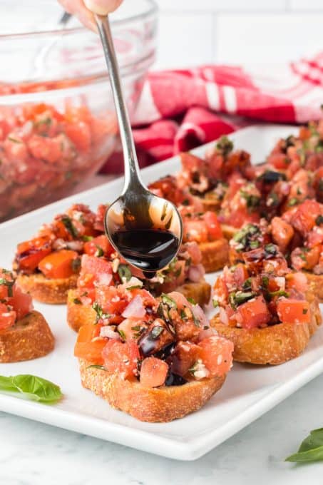 Drizzling a balsamic glaze on bruschetta.