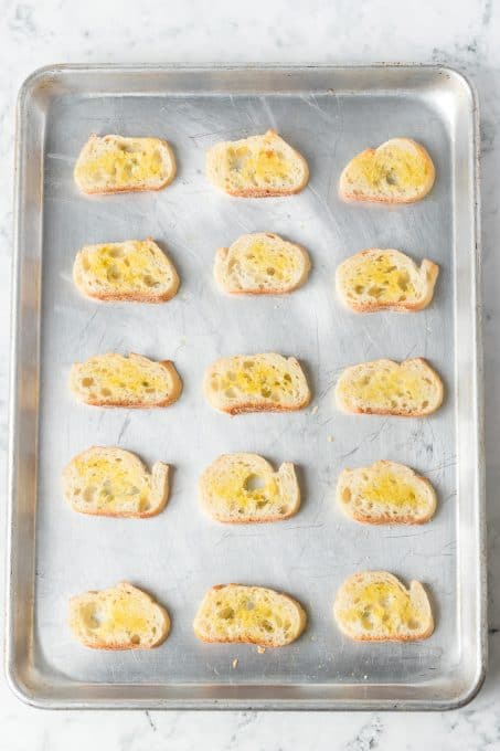 Bread slices brushed with olive oil ready to be toasted.