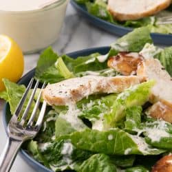 A salad with chicken and Caesar dressing.