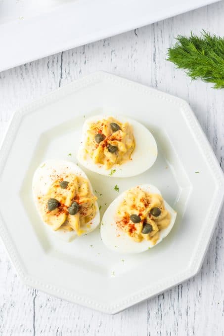 Capers and fresh dill top an egg appetizer.