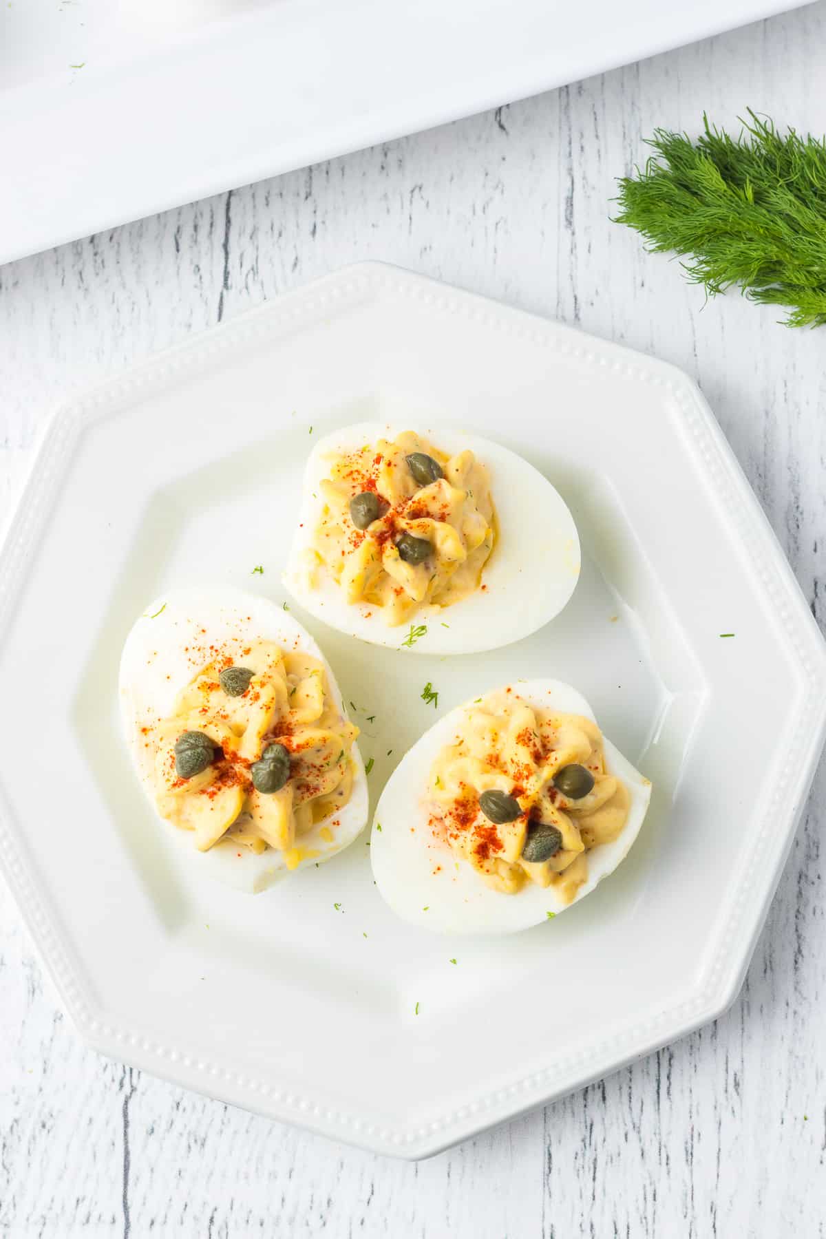 Capers and fresh dill top an egg appetizer.