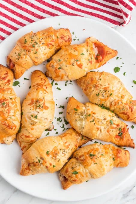 A plate of crescent rolls filled with pepperoni and Mozzarella cheese.