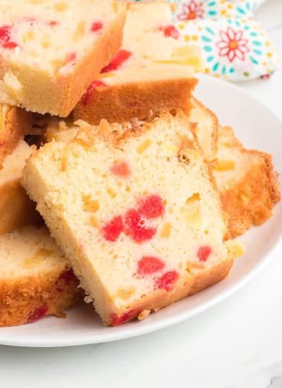 Slices of a coconut quick bread with cherries and pineapple.