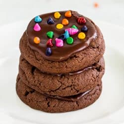 A stack of Brownie Cookies with chocolate frosting and cosmic sprinkles.
