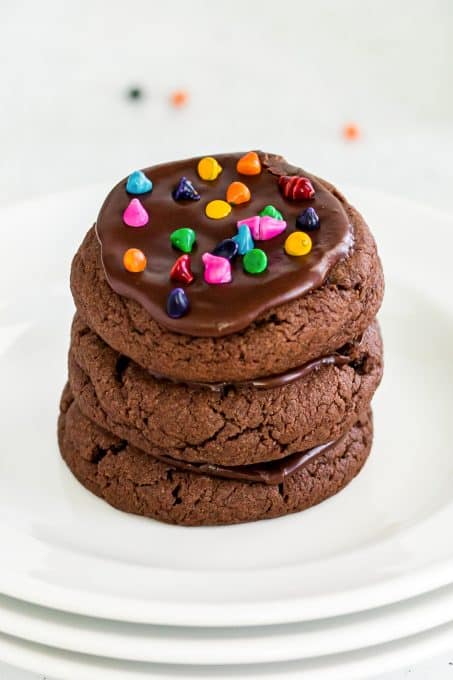 A stack of Brownie Cookies with chocolate frosting and cosmic sprinkles.