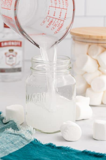 Pouring the finished product into a mason jar for safe keeping.