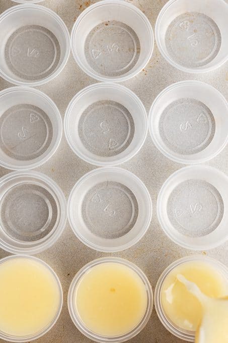 Pouring the pineapple coconut gelatin into jello shot containers.