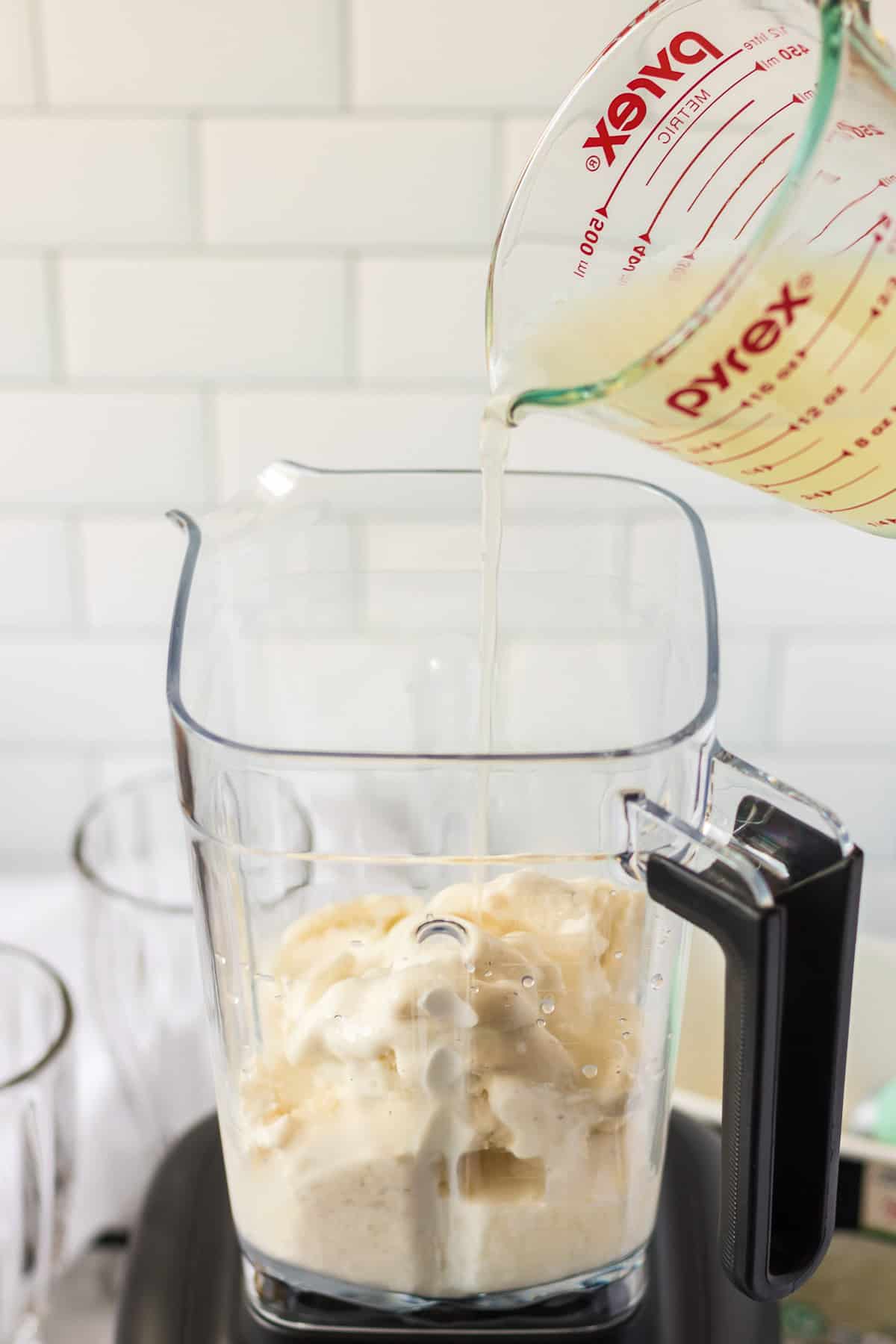Pouring lemonade into a blender with ice cream.