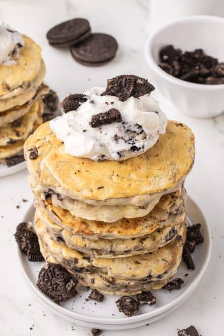 Whipped cream on pancakes with crushed Oreos.