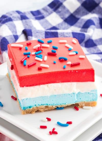 A vanilla cheesecake center with a blue raspberry gelatin bottom and cherry gelatin top.