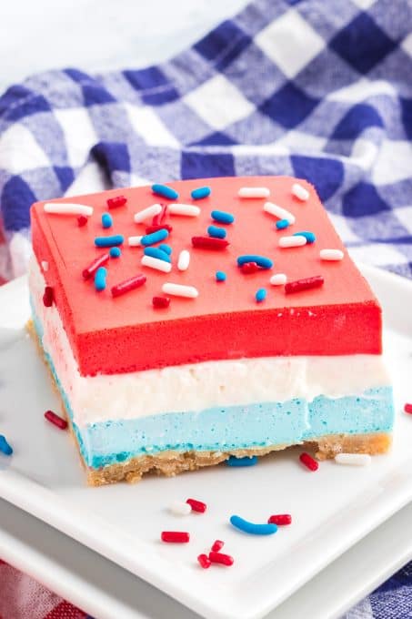 A vanilla cheesecake center with a blue raspberry gelatin bottom and cherry gelatin top.
