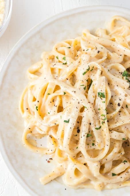 Pasta noodles with a white, creamy garlic sauce.