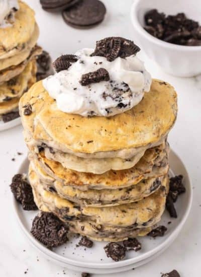 Whipped cream on pancakes with crushed Oreos.