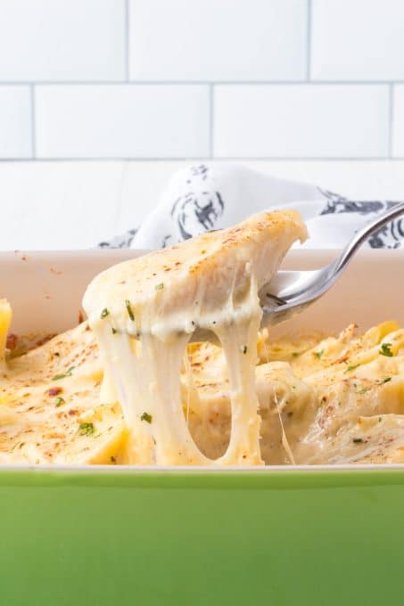 Pulling a shell and cheese out of a casserole dish.