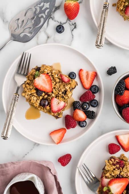 A plate of oatmeal with fresh berries that has been baked in the oven.