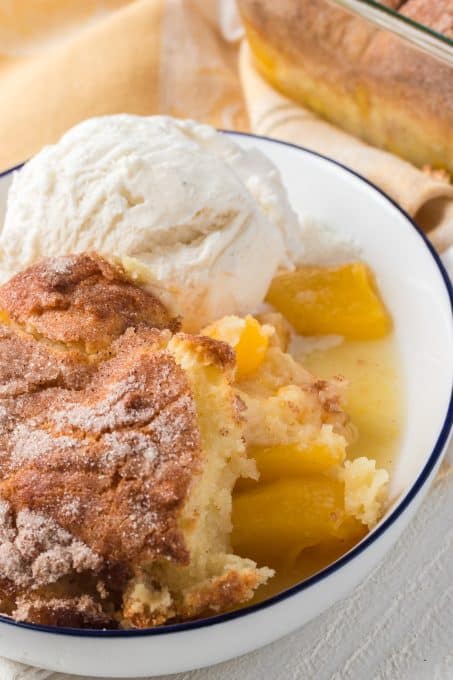 Cobbler made with fresh peaches with a scoop of vanilla ice cream.