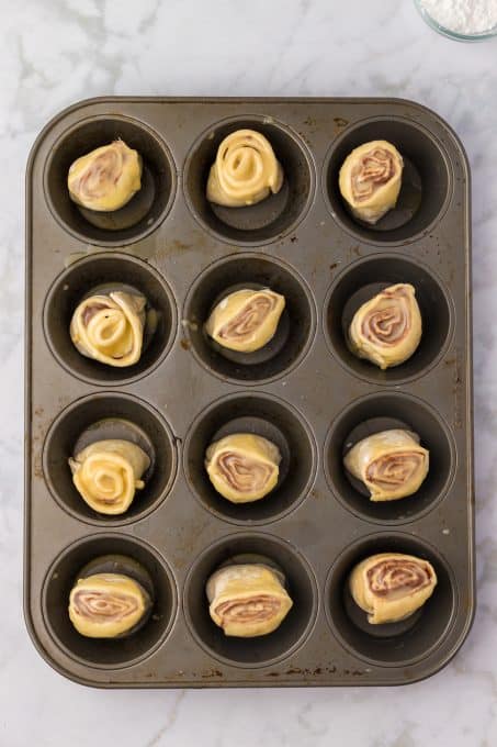 Puff Pastry Nutella Rolls in a muffin tin.