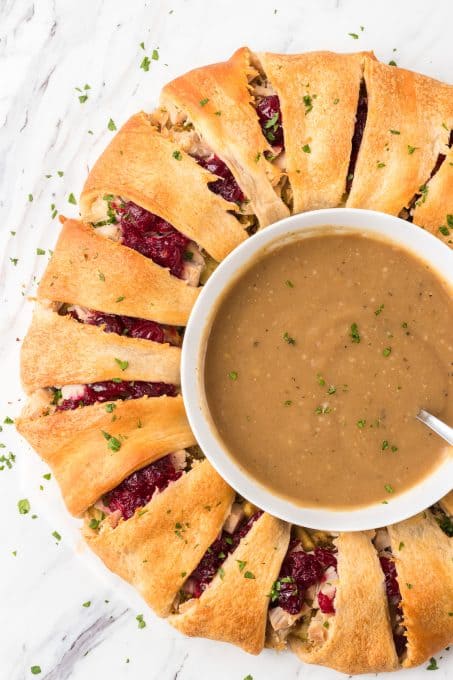 A bowl of gravy in the center of an easy Turkey Ring.