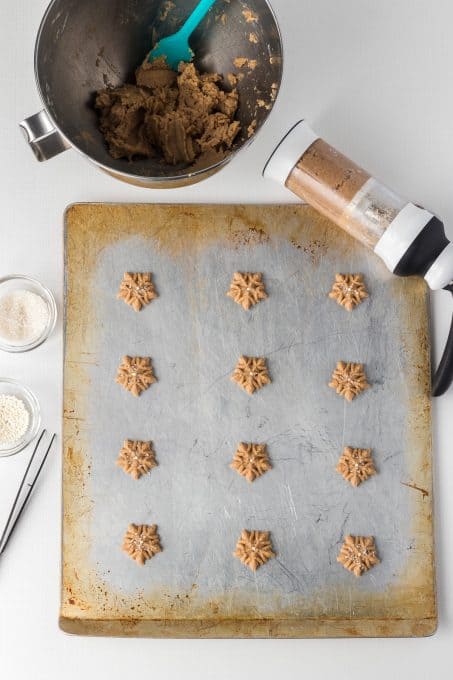 Using a cookie press to make Spritz Cookies with Chai spices.