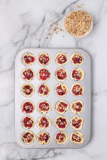 Puff pastry dough filled with brie and cranberries and topped with hazelnuts.