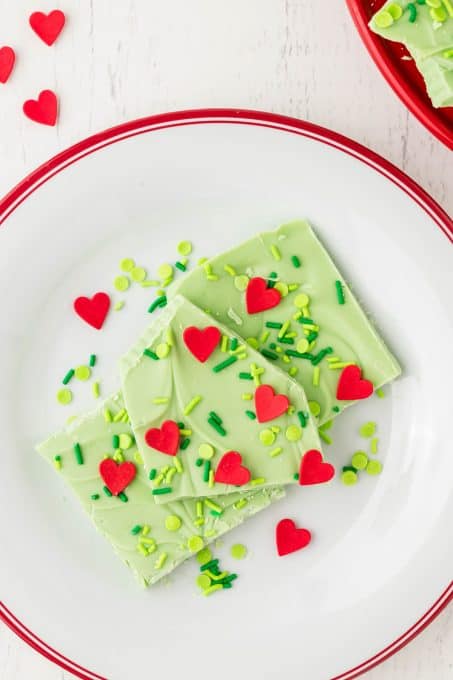 White chocolate bark with green sprinkles and red hearts for a Grinch theme.