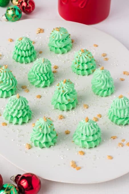 Green meringues shaped and decorated as Christmas trees.