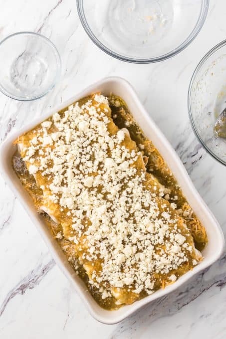 Queso Fresco on top of a dish of enchiladas.