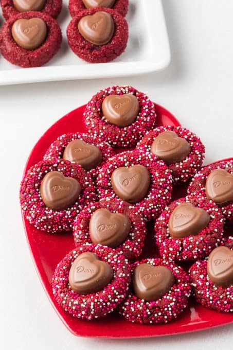 A chocolate heart in the middle of red velvet cookies.