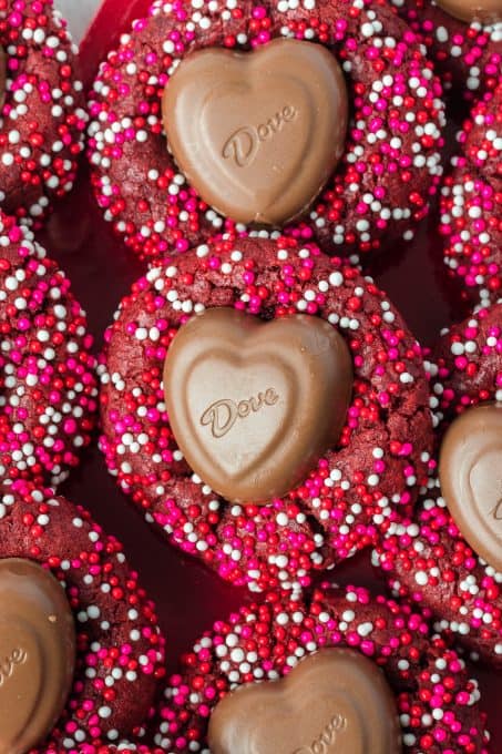 Valentine nonpareils cover a red velvet cookie that has a chocolate heart in the center.