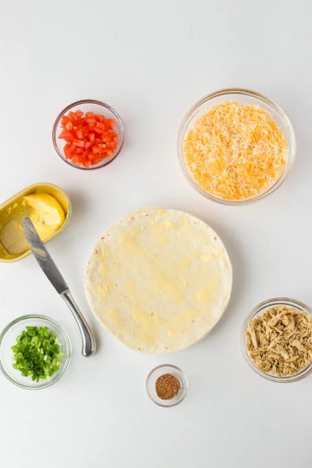 Spreading butter on a tortilla.