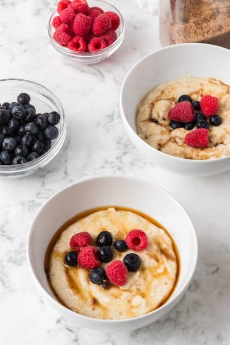 Bowls of hot porridge topped with fresh fruit.