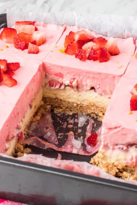 No bake dream bars with lemon cheesecake and strawberries in the pan.