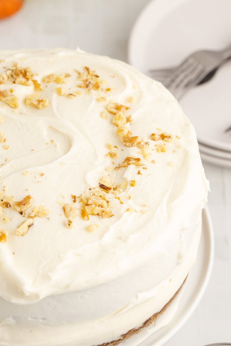 Walnuts on top of a cake made with carrots and pineapple.