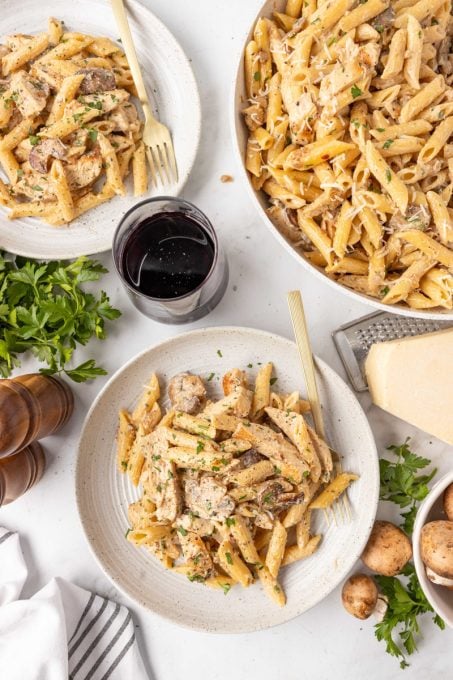 Plates of creamy cheese pasta with mushrooms and chicken.