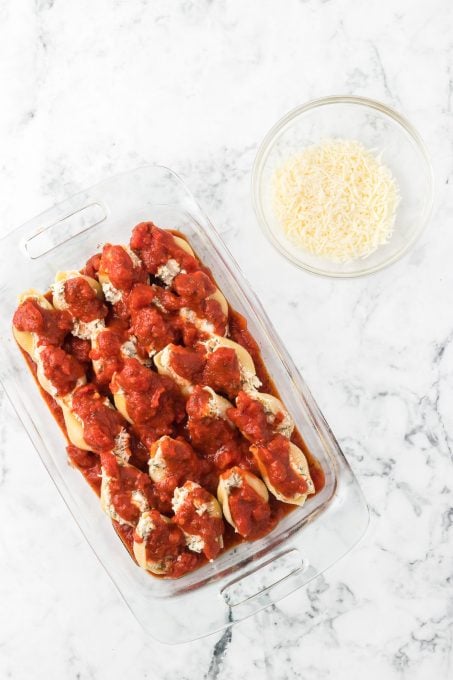 Pasta sauce on stuffed shells with chicken ready for the oven.