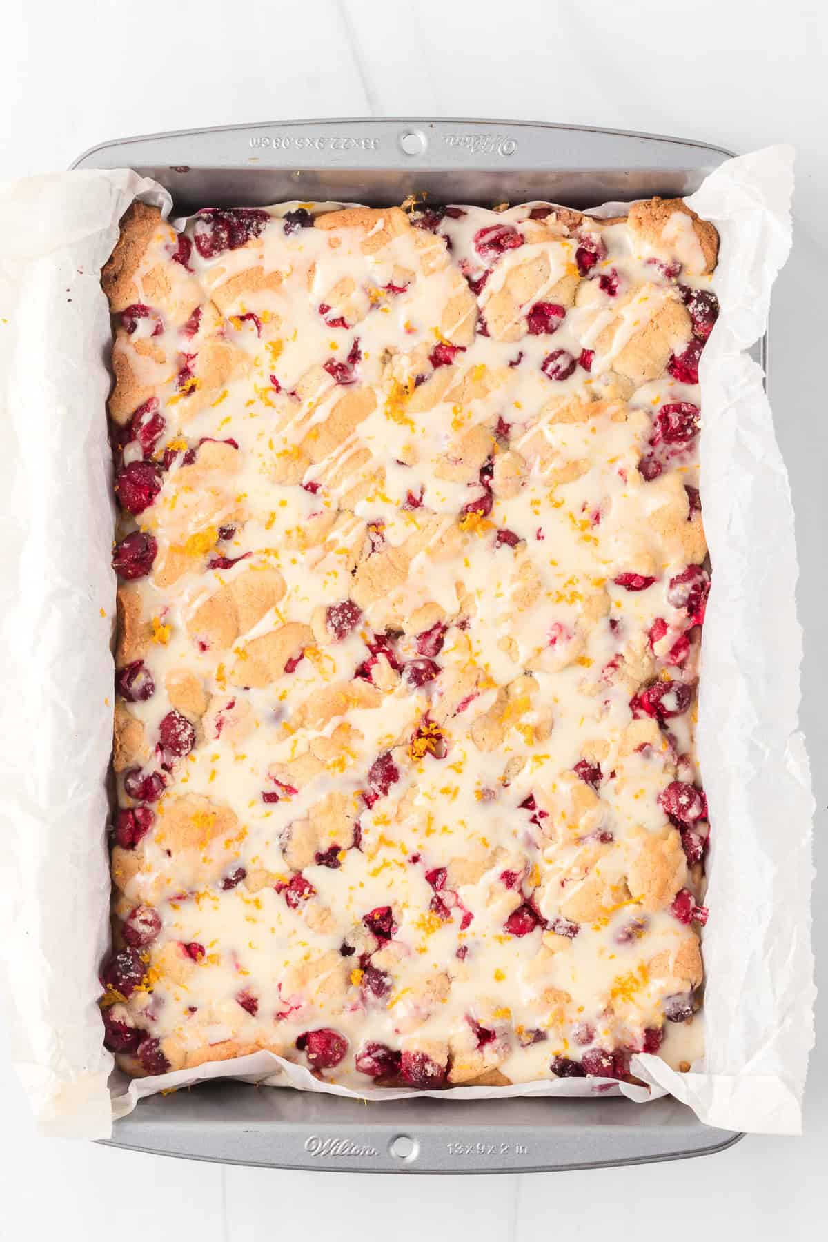 Freshly baked pie bars with cranberries and a citrus glaze.