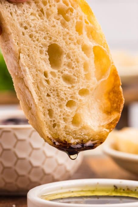 Olive oil and Balsamic vinegar dripping off a slice of bread.