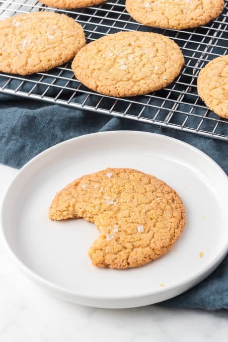 A cookie on a plate with a bite taken out of it.