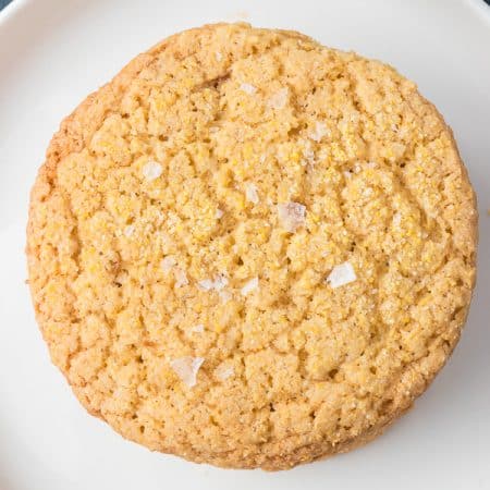 A single Cornmeal Cookie on a plate.