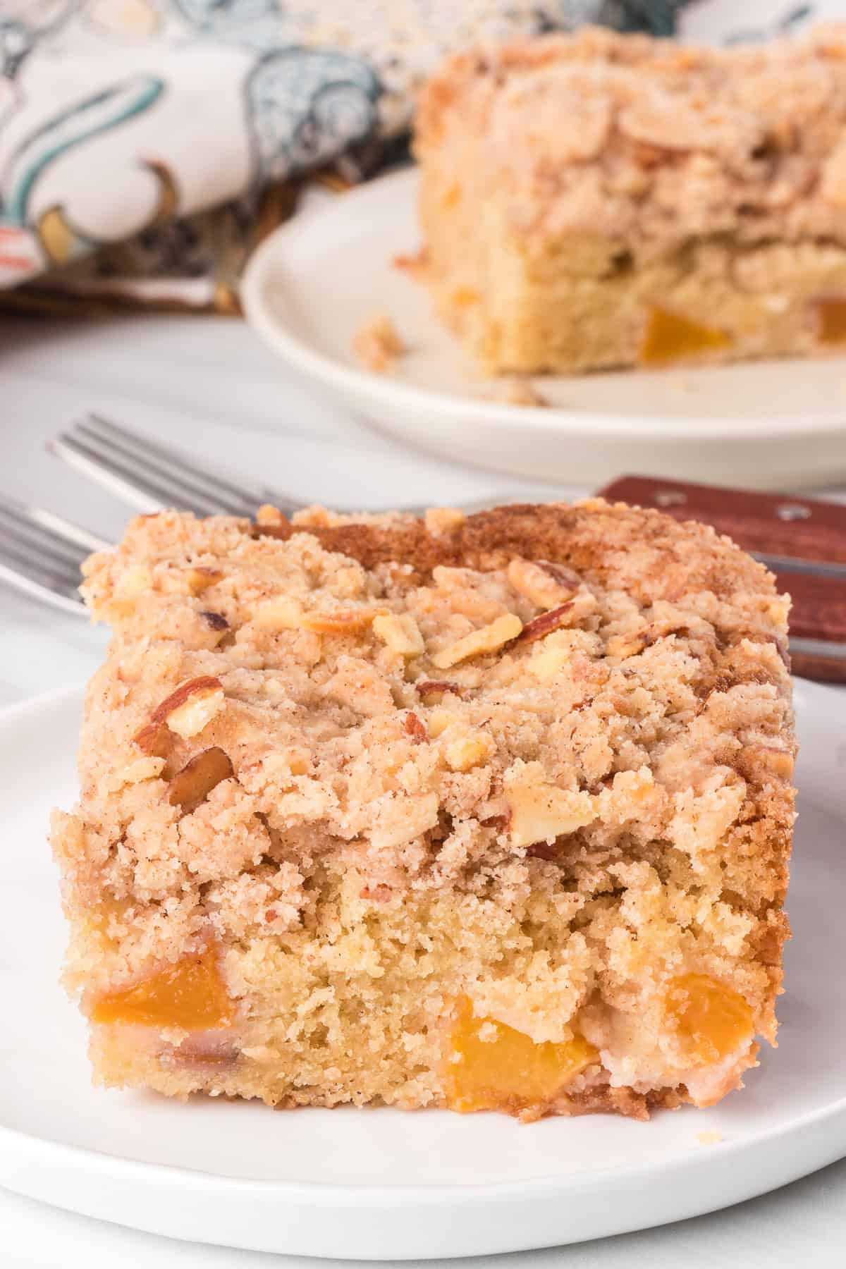 Slices of peach cake on plates with a floral napkin