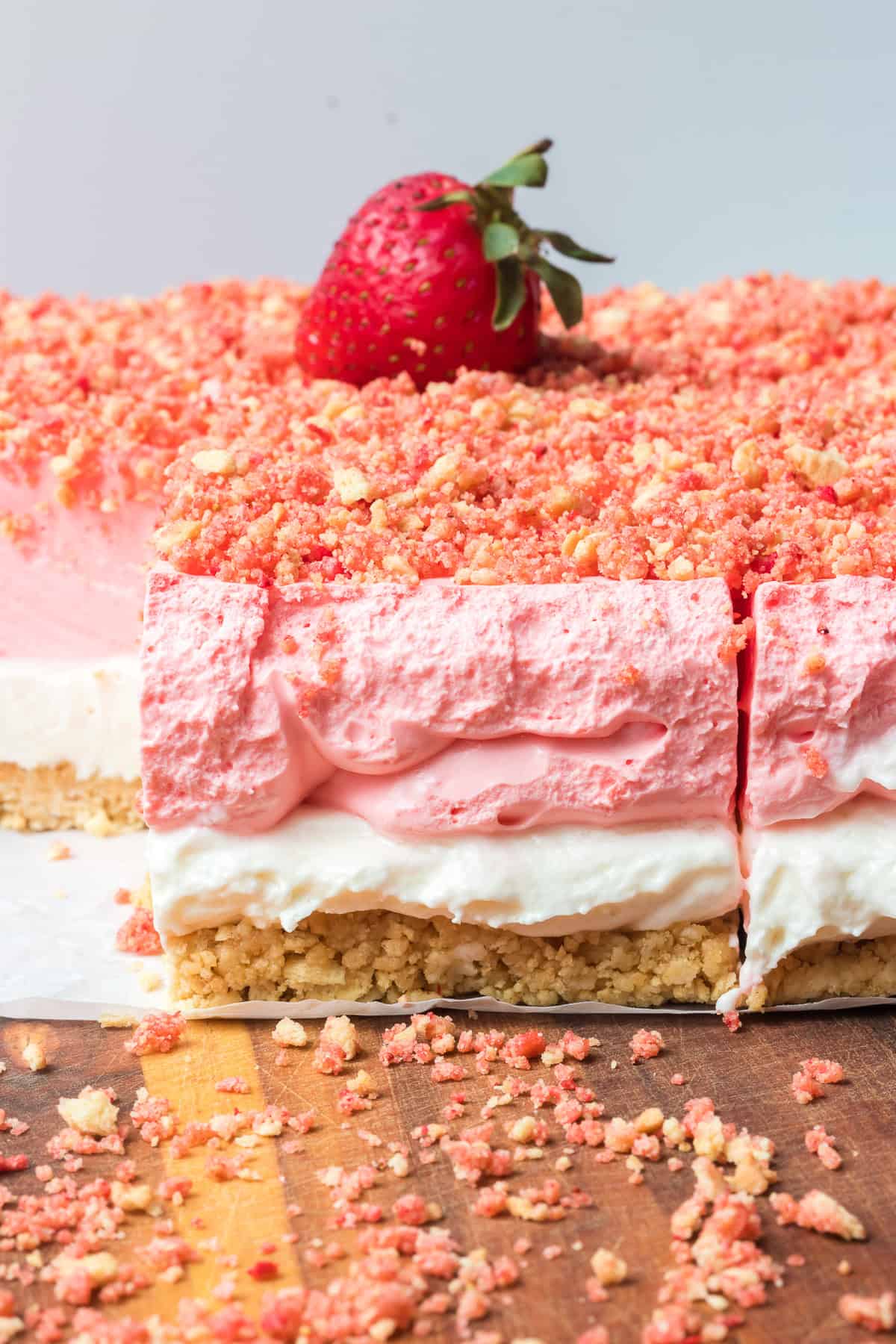 A strawberry on top of a creamy strawberry gelatin dessert.