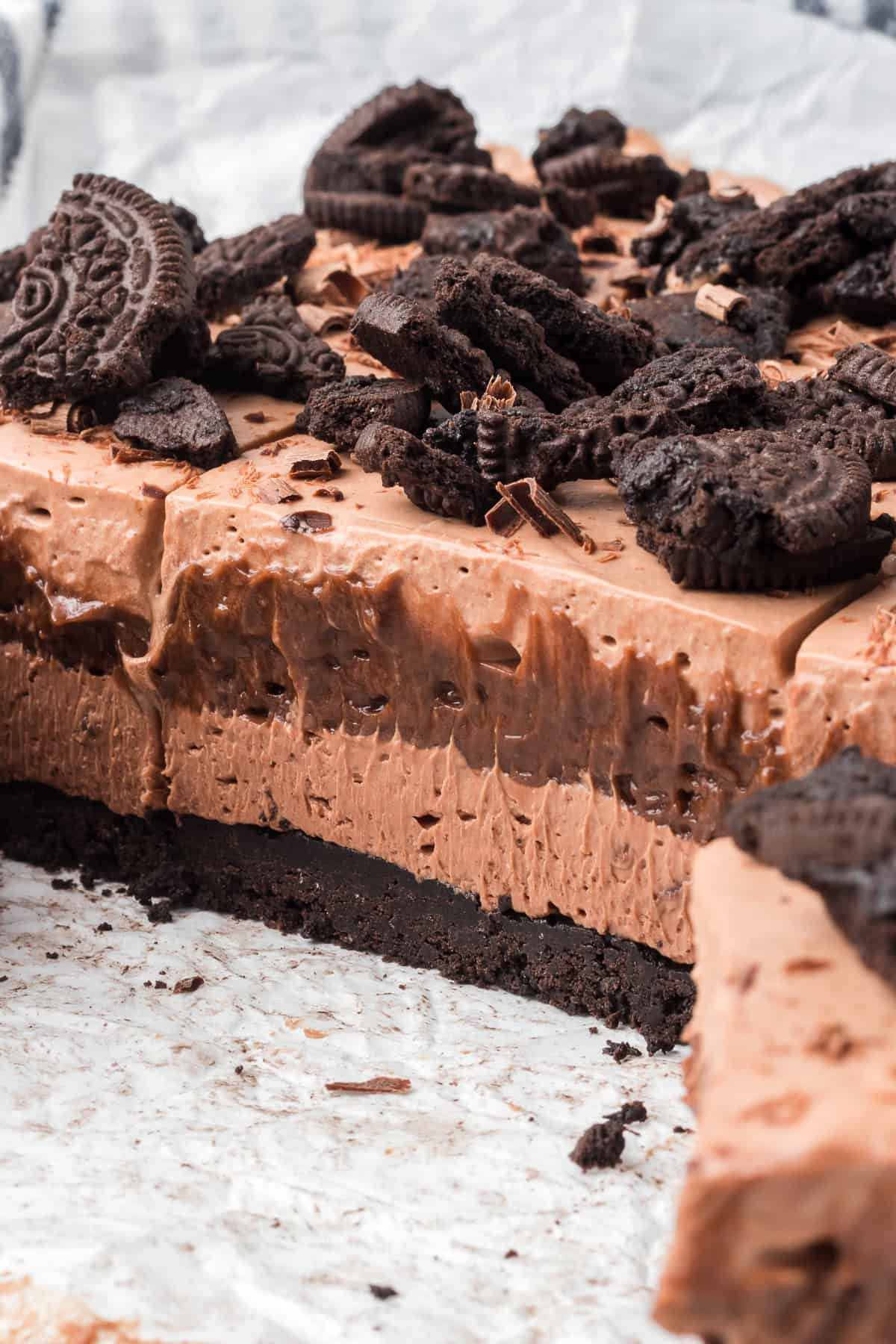 Layers of chocolate whipped cream, chocolate pudding, chocolate cheesecake on top of a chocolate Oreo crust.