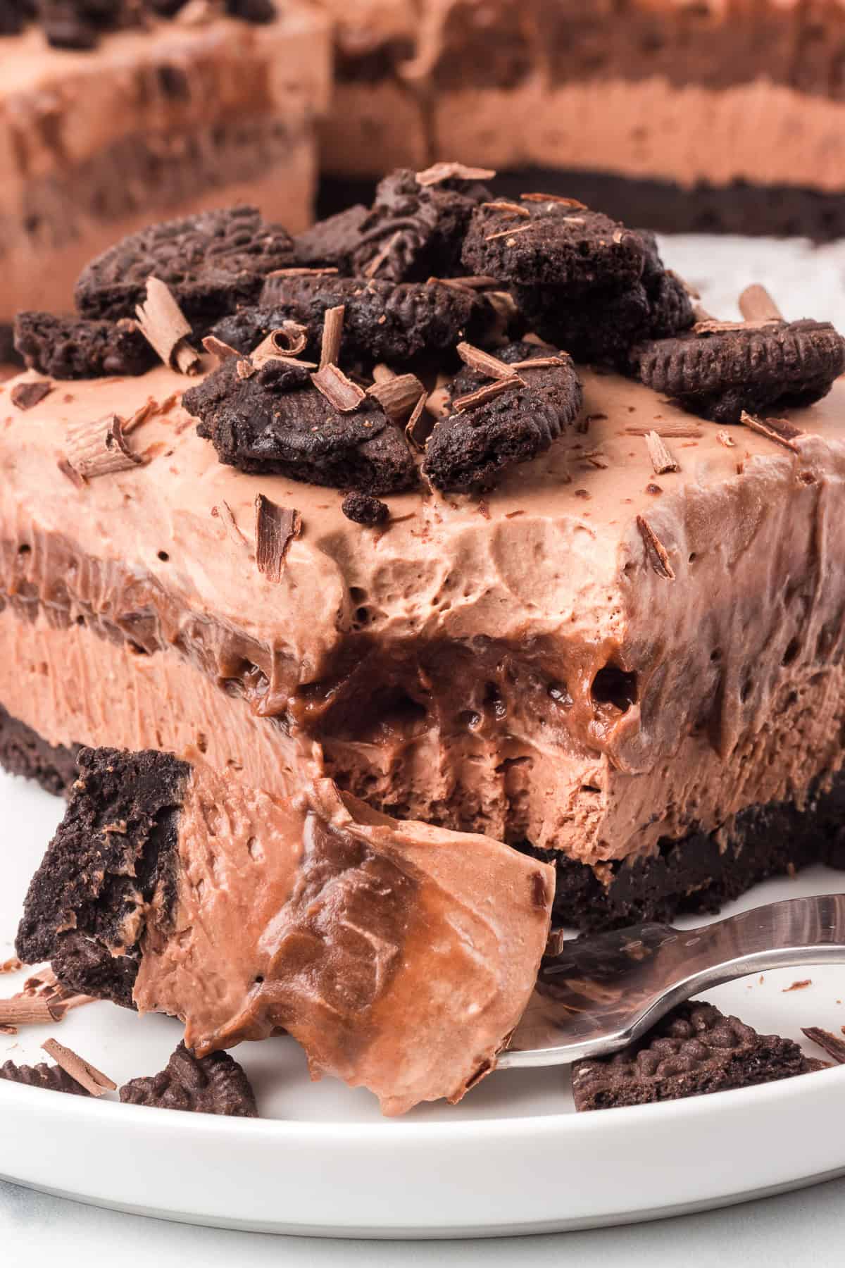 A bite taken out of a no bake chocolate layered dessert.